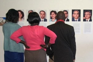 Des participants à la conférence « Cinq années de trop » en Ouganda regardant des photos des sept responsables bahá'ís iraniens emprisonnés. L'événement, qui a eu lieu le 15 mai à Kampala, a présenté un appel du Conseil interreligieux d'Ouganda demandant à l'Iran de respecter les droits des minorités religieuses.